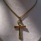 Gold necklace with an ankh pendant displayed on a mannequin bust.