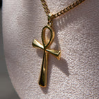 Gold necklace with an ankh pendant displayed on a mannequin bust.