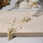 A gold-toned, tightly spiralled nose cuff sits on the model's nose. The design begins with a tightly formed circle that gradually twists in a wavy pattern. It is accompanied by a faux lip ring cuffing the model's bottom lip. The flexible wire is tightly moulded to create a circular spiral shape that gradually decreases in size.