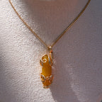Gold wire-wrapped yellow agate pendant necklace displayed on a white fabric bust
