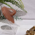 A silver-toned nose cuff adorns the model's nose in a circular wire design that spirals up and gradually decreases in size.