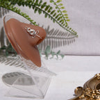 A silver-toned nose cuff adorns the model's nose in a circular wire design that spirals up and gradually decreases in size.