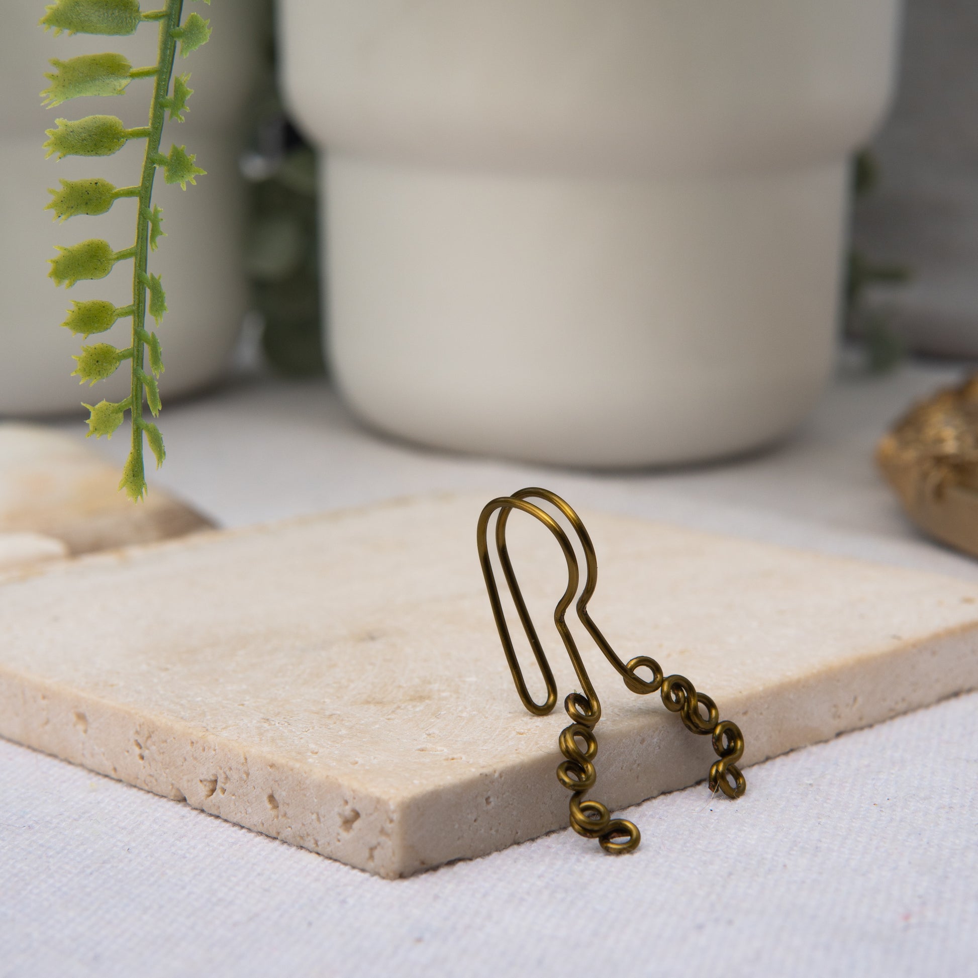 This is a bronze-toned faux lip ring made with light gold copper wire. The wire design spirals into two diagonal directions, forming five tightly moulded circles.